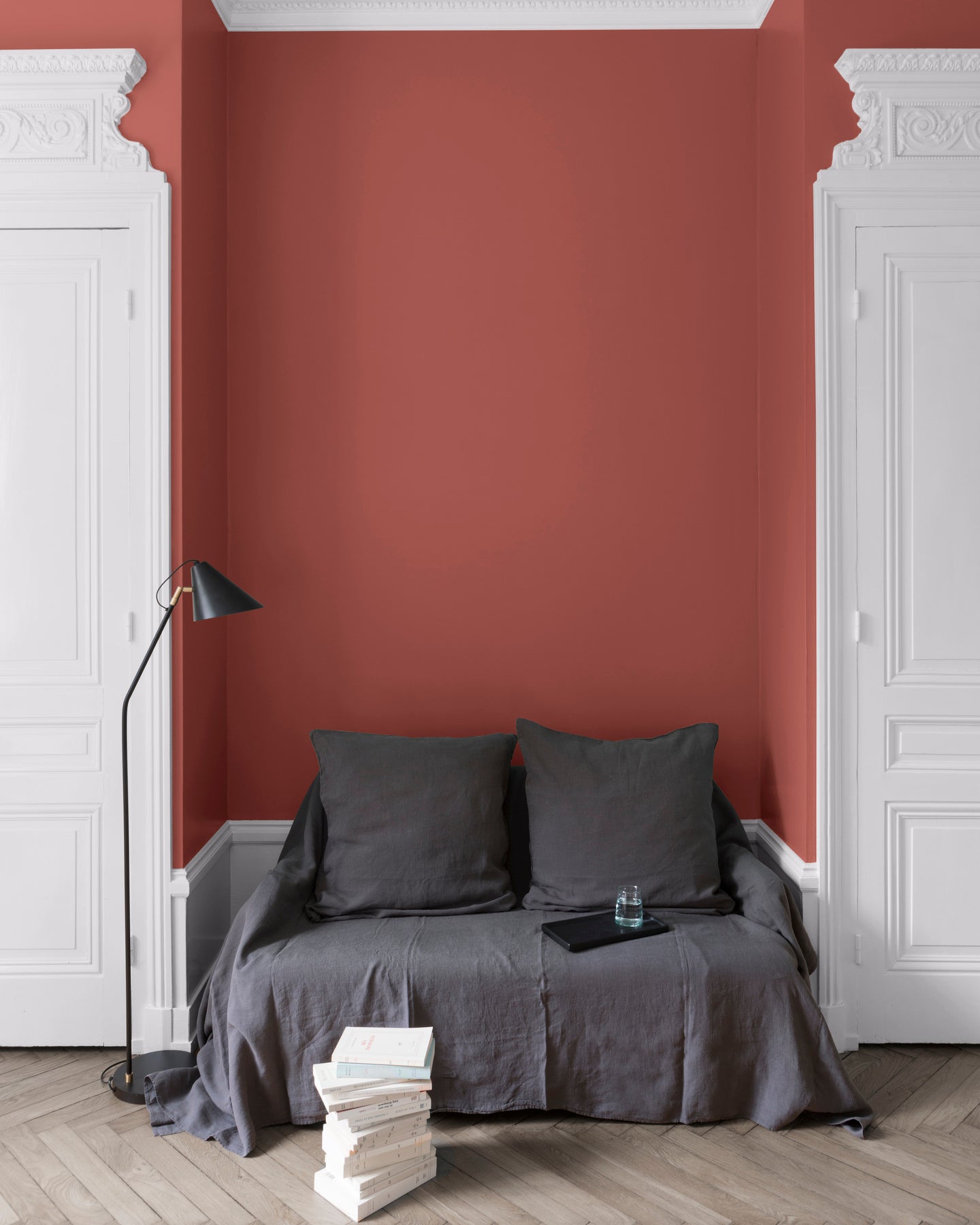 Salon aux murs rouges, peinture Velours de Peinture Rouge de Bourgogne Libéron avec portes blanches et textiles gris.
