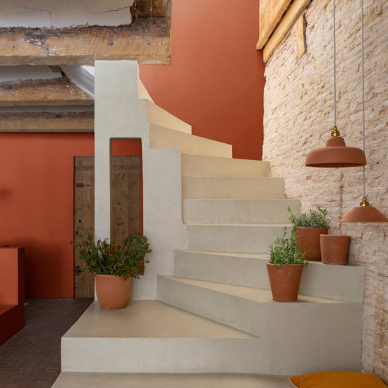 Escaliers blancs, avec mur en pierre et murs oranges, peinture Velours de Peinture Roux du Goupil Libéron, et pots de fleurs en argile