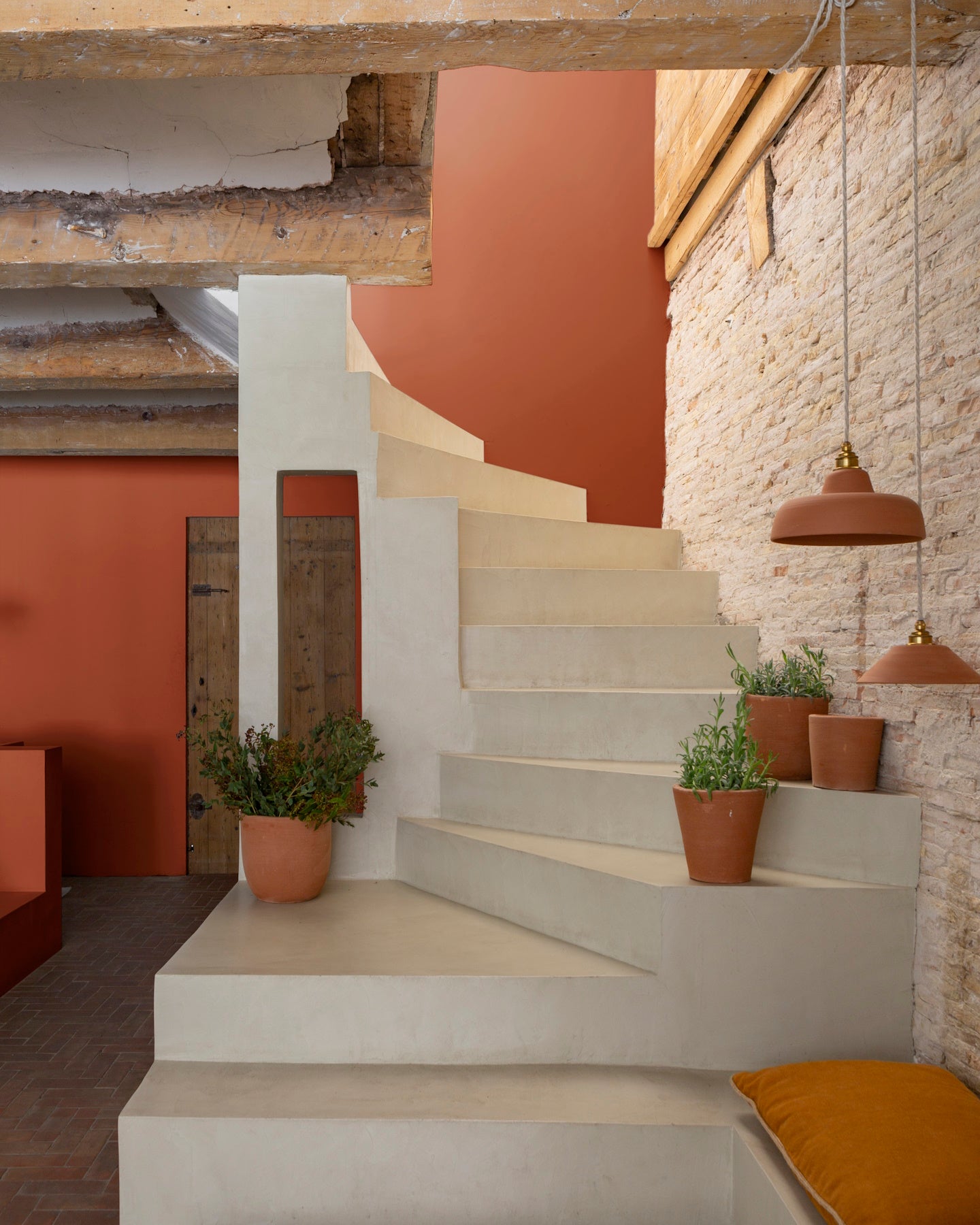 Escaliers blancs, avec mur en pierre et murs oranges, peinture Velours de Peinture Roux du Goupil Libéron, et pots de fleurs en argile