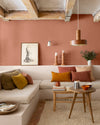 Salon aux murs terre cuite d’Anjou, Velours de Peinture Libéron, avec banquette maçonnée, coussins chauds et poutres en bois.