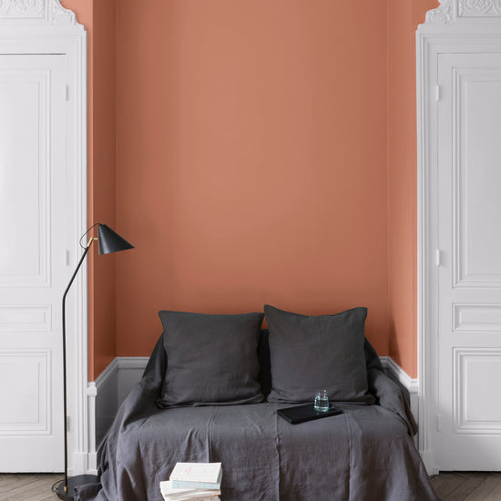 Salon aux murs Terre Cuite, Velours de Peinture Libéron, avec canapé gris, portes blanches et parquet clair.