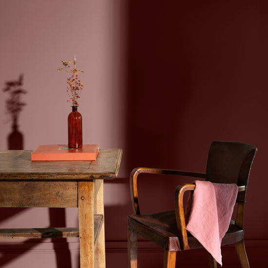 Pièce à vivre avec murs rouges, peinture Velours de Peinture Terre de Rougier Libéron, avec table et chaise en bois