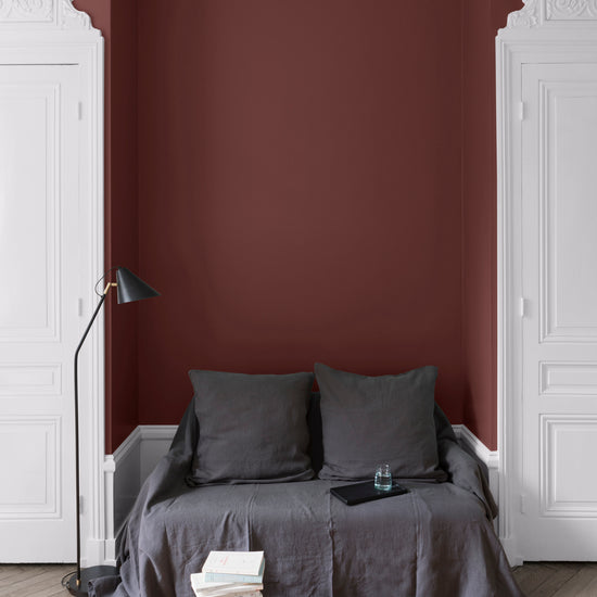 Salon aux murs Terre de Rougier, Velours de Peinture Libéron, avec canapé gris, portes blanches et parquet clair.