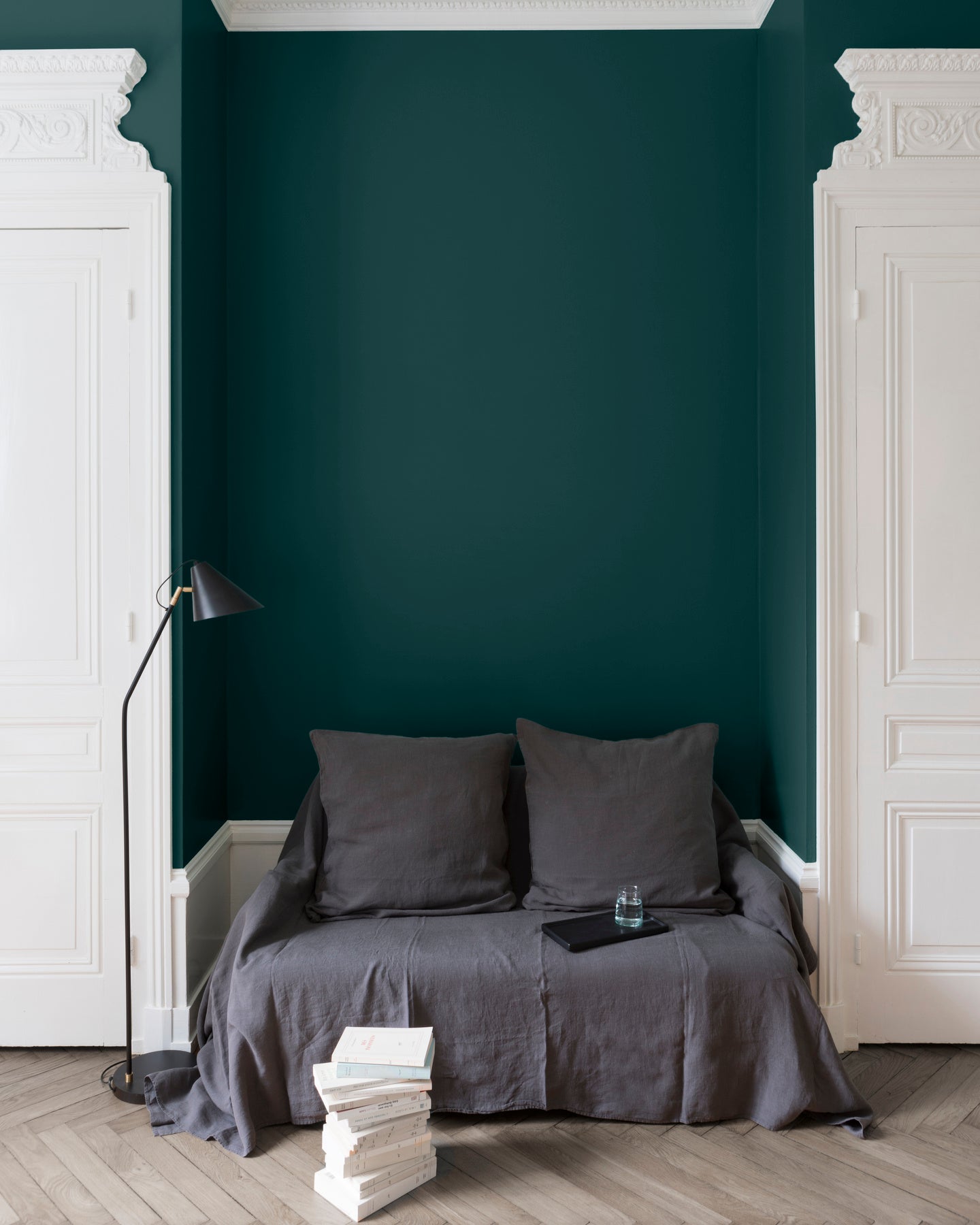 Salon aux murs Vert au Tableau, Velours de Peinture Libéron, avec canapé gris, portes blanches et parquet clair.