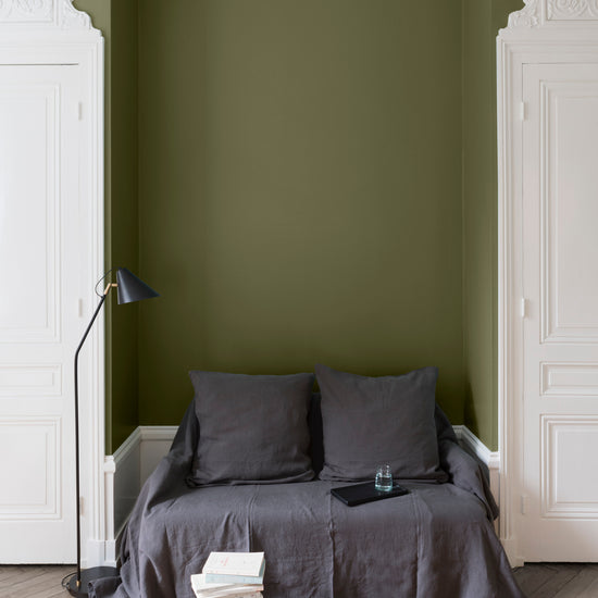 Salon aux murs Vert Bocage, Velours de Peinture Libéron, avec canapé gris, portes blanches et parquet clair.
