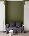 Salon aux murs Vert Bocage, Velours de Peinture Libéron, avec canapé gris, portes blanches et parquet clair.