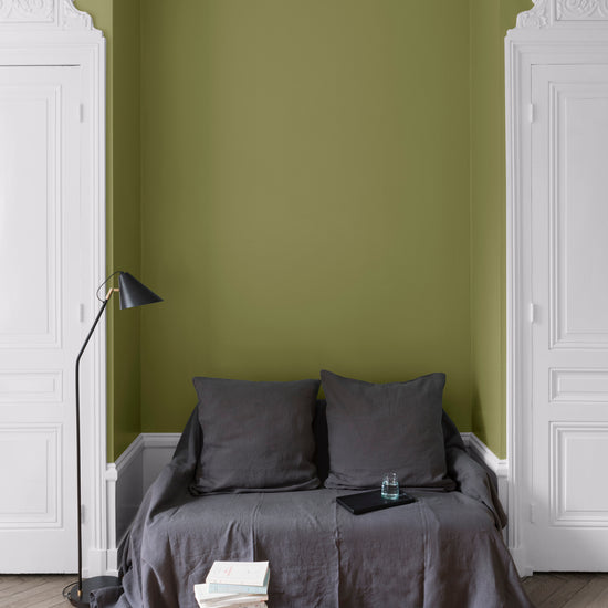Salon aux murs Vert Herbarium, Velours de Peinture Libéron, avec canapé gris, portes blanches et parquet clair.