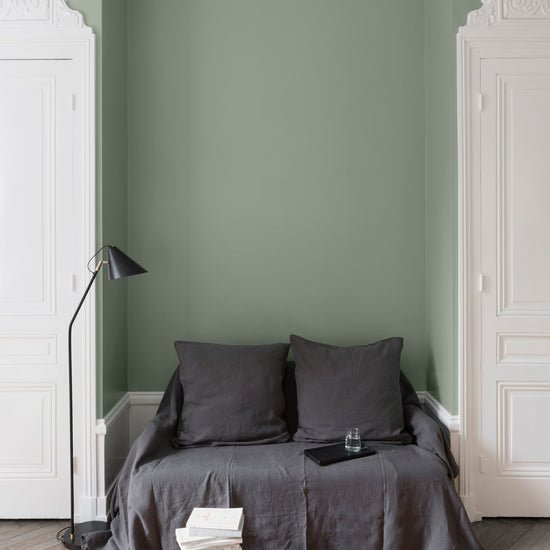 Salon aux murs verts, peinture Velours de Peinture Vert Luxembourg Libéron avec portes blanches et textiles gris.