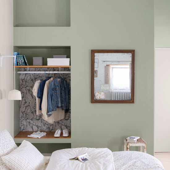 Chambre aux murs vert sauge Libéron, avec alcôve dressing, miroir en bois, linge blanc et décoration douce.