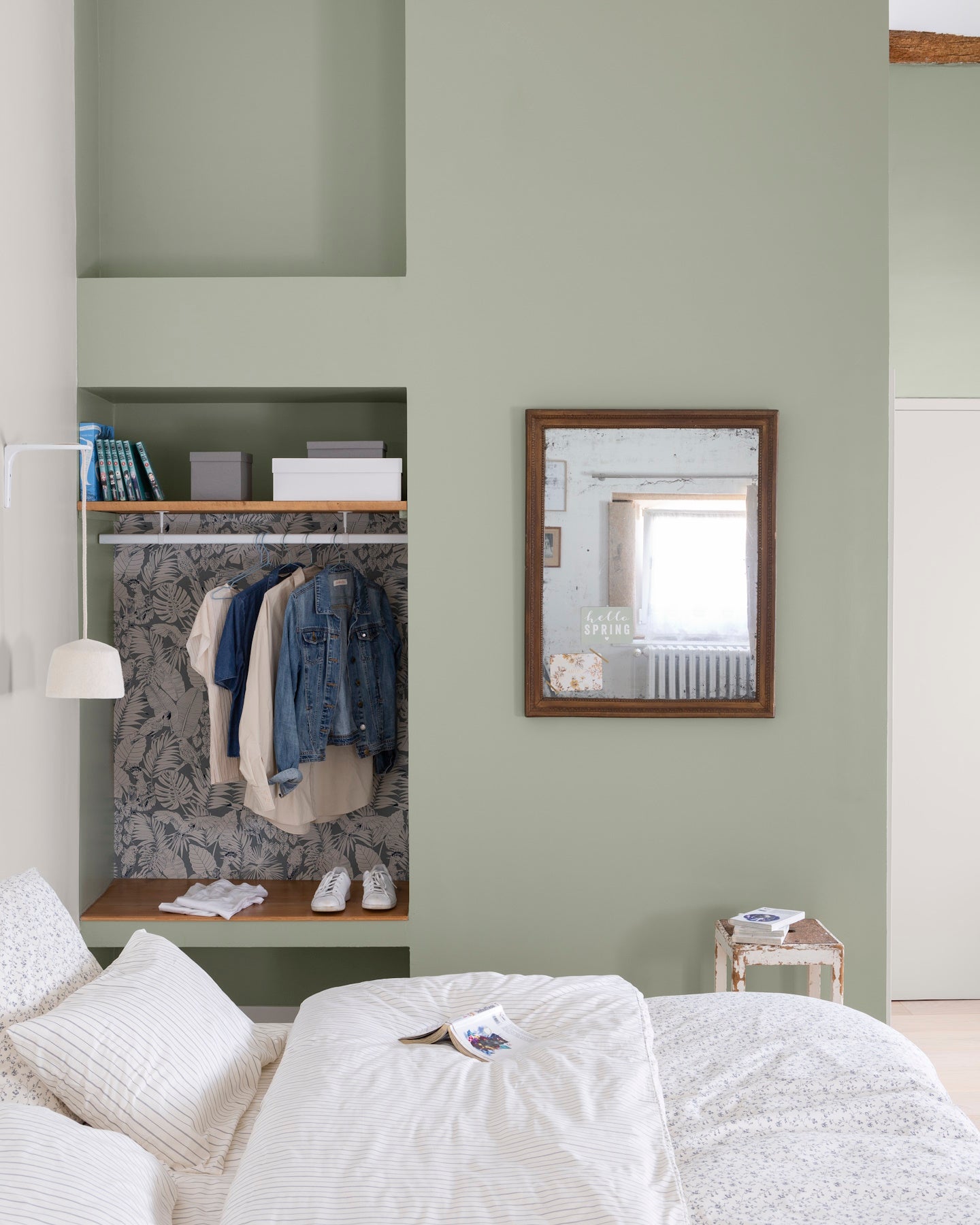 Chambre aux murs vert sauge Libéron, avec alcôve dressing, miroir en bois, linge blanc et décoration douce.
