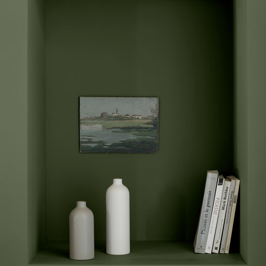 Niche murale vert treillis Libéron avec tableau de paysage, vases blancs et livres posés sur une étagère peinte.