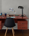 Coin bureau verni avec le Vernis Bistrot Acajou Libéron, chaise et lampe noires, photos accrochées sur le mur gris.