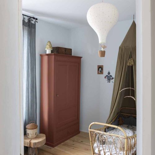 Photo d'ambiance d'une chambre, montrant un meuble peint avec la peinture Libéron Meuble Signé Mat Rouge Pouzzolane